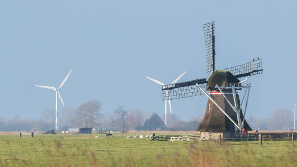 istock Old windmill with modern windmills in the background 912898264