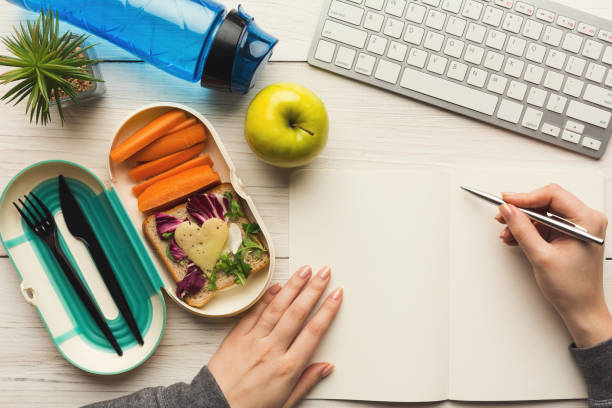 istock Woman eating healthy dinner from lunch box at her working table 912899400