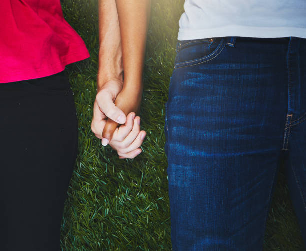 istock High-angle, cropped look at hand-holding couple lying on grass 912902678
