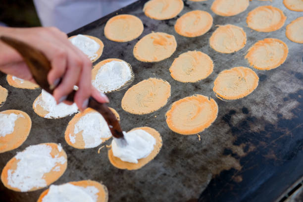istock Row of Thai crispy pancakes on hot pan (Thai sweet) 912903182