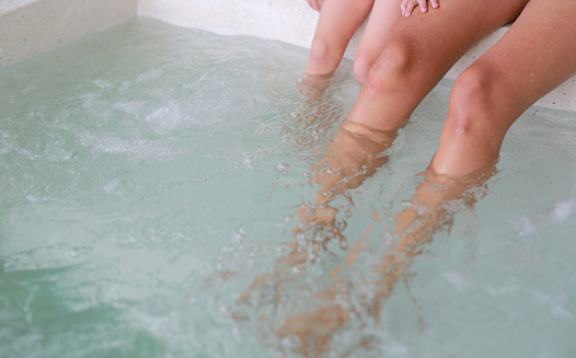 Woman with her daughter foot in hot tub hot tub.