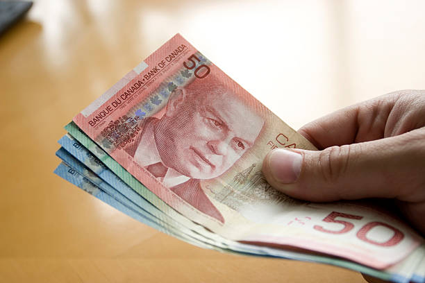 dinero en la mano - canadian currency fotografías e imágenes de stock