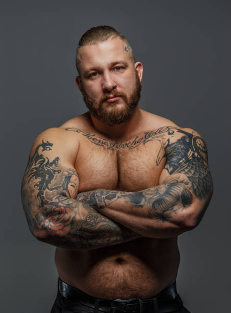 Strict male with beard and tattooes Serious calm musculed male with beard and tattooes pectoral muscle stock pictures, royalty-free photos & images