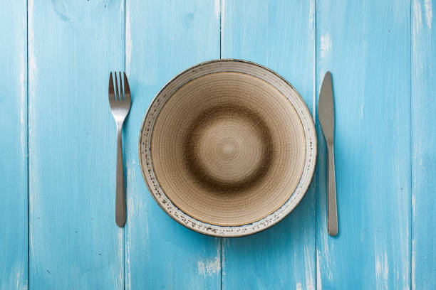 istock Plate on blue wooden background with utensils 912913696