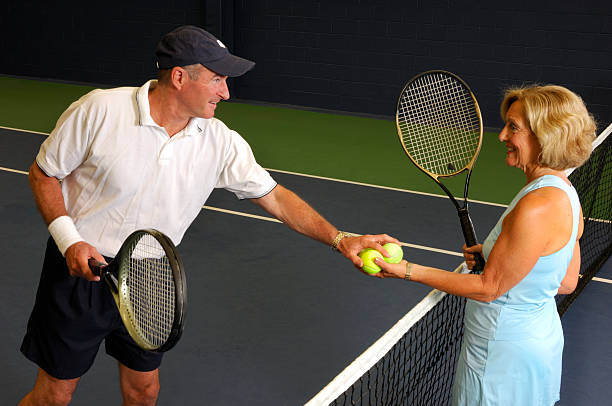 senior salute e fitness partita di tennis - tennis baseline fun sports and fitness foto e immagini stock