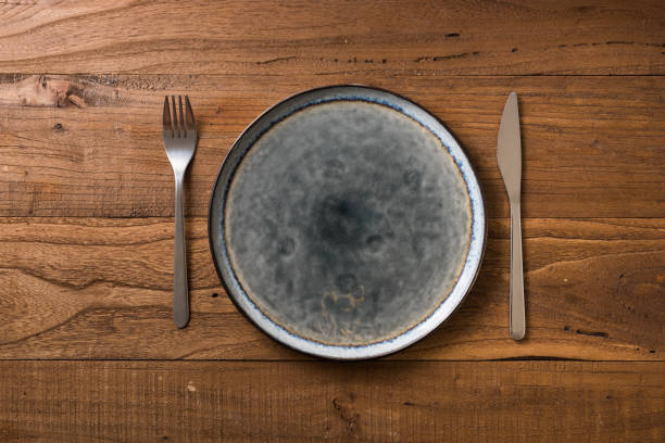 istock Plate on brown wooden background with utensils 912915028