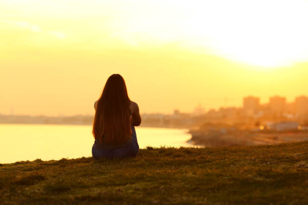 donna che vede un tramonto sulla città - destinies foto e immagini stock