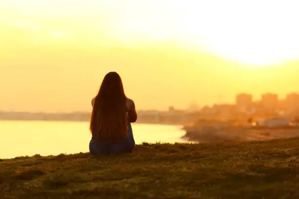 Photo of Woman seeing a sunset on the city