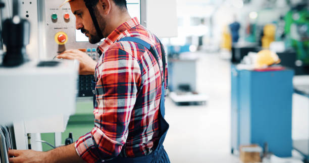 istock Industry Worker entering data in CNC machine at factory 912919136