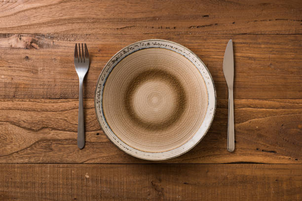 istock Plate on brown wooden background with utensils 912920140