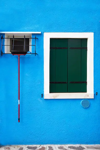 Photo of Windows with closed green shutters on the famous island Burano, Venice, Italy