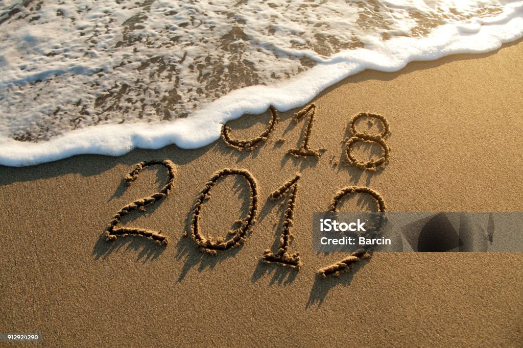 New year 2019 New year 2019 and old year 2018 written on sandy beach with waves Backgrounds Stock Photo