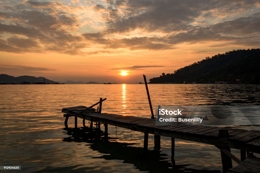 tropical sunrise with wooden jetty over island tropical sunrise with wooden jetty over lonely island 2017 Stock Photo