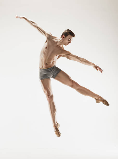 istock Athletic ballet dancer in a perfect shape performing over the grey background 912925110