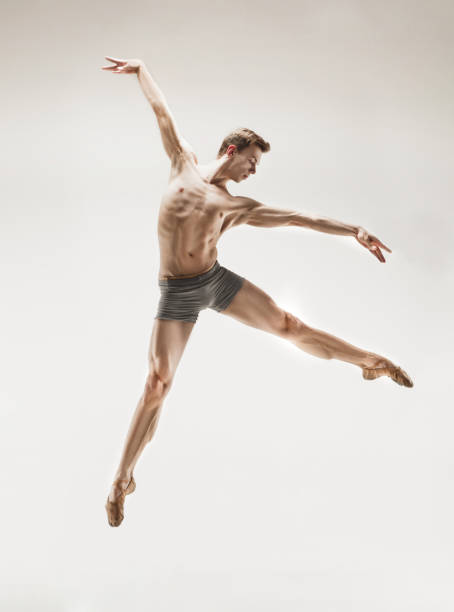 istock Athletic ballet dancer in a perfect shape performing over the grey background 912925112