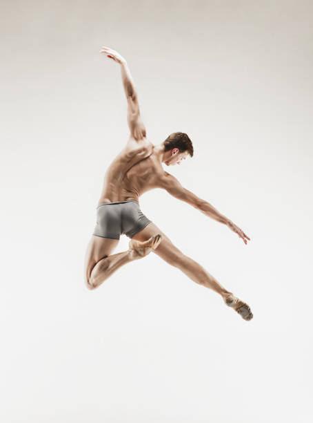 istock Athletic ballet dancer in a perfect shape performing over the grey background 912925168