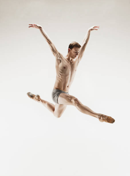 istock Athletic ballet dancer in a perfect shape performing over the grey background 912925194