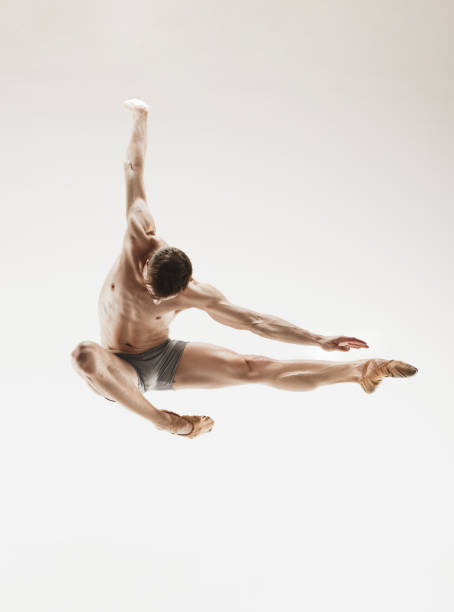 istock Athletic ballet dancer in a perfect shape performing over the grey background 912925318