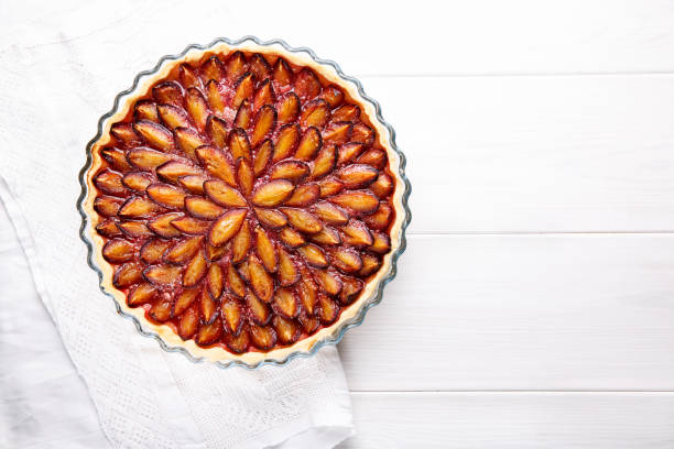 istock Homemade plum pie. Fruit tart on white table. Copy space. Top view. 912927894