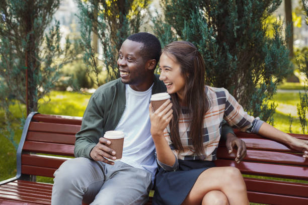 istock Multiethnic couple in love having coffee in park 912931302