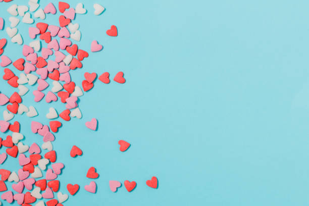 candies hearts of pastel colors on blue paper. flat lay. - lots of candy hearts imagens e fotografias de stock