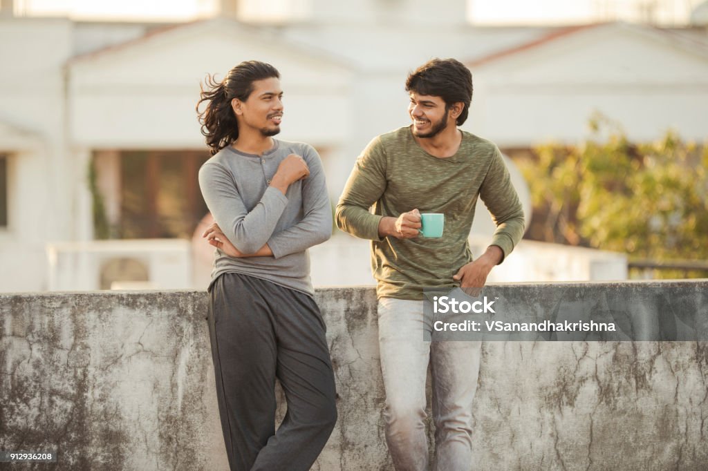 Cheerful young friends chatting Cheerful young friends chatting on terrace. Friendship Stock Photo
