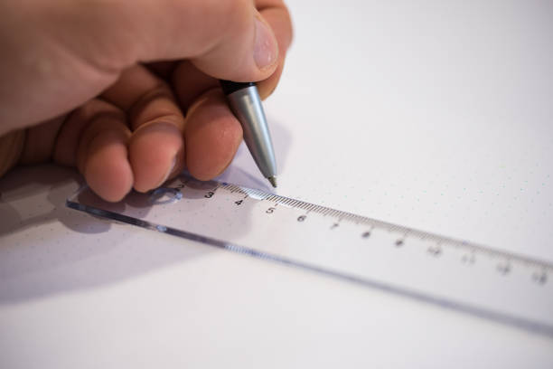 istock Person using a ruler and a pen 912944750