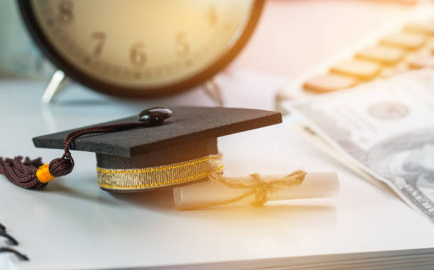 istock Graduate study international abroad concept, Graduation cap scroll certificate near documents report chart,blur US Dollar. Graduate study abroad program for students foreign, Finance Education Concept 912945276