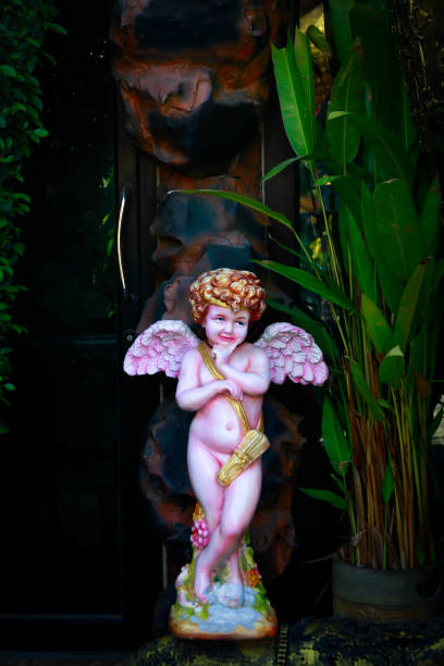 istock Standing pink baby angel statue in A Garden. Selective Focus and Blurred Background.Image made vintage ton 912955084