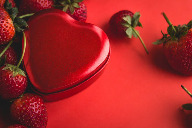 istock Valentine red heart and strawberry on red background 912960964