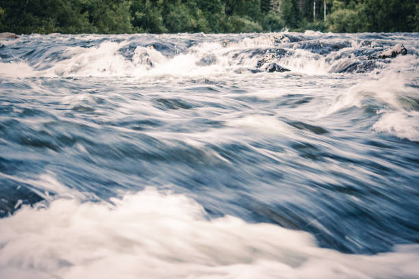 A powerful stream of mountain river. The fast current of water.