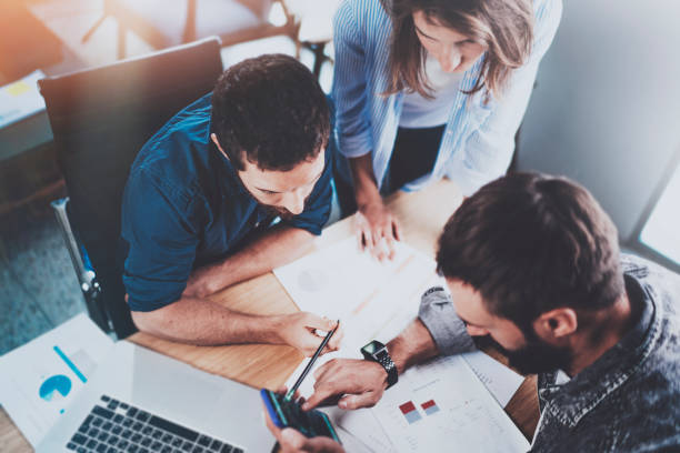 istock Teamwork working process.Group of young coworkers working together in modern office loft.Man using mobile phone.Blurred background.Flares. 912964210