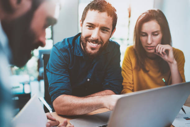 istock Teamwork concept.Coworking process at sunny loft office.Young Business team making conversation at meeting room.Horizontal.Blurred background. 912972406