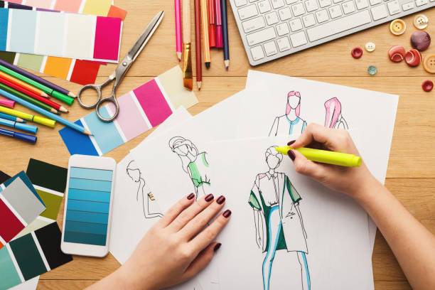 istock Top view on woman designer drawing clothes sketches 912984894