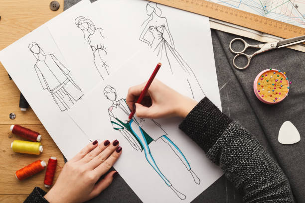 istock Top view on woman designer drawing clothes sketches 912986054