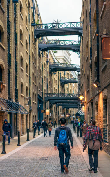 Visiting London's Shad Thames London, UK - People walking on Shad Thames in Bermondsey, located just south of the River Thames, by Tower Bridge. bermondsey street restaurants stock pictures, royalty-free photos & images