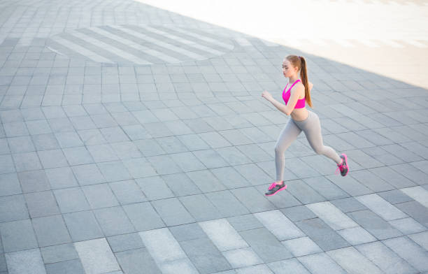 istock Young woman running in city copy space 912989096