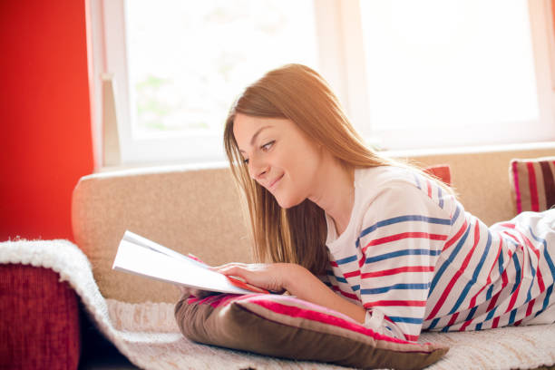 istock Girl relaxing with magazine on sofa 912989324