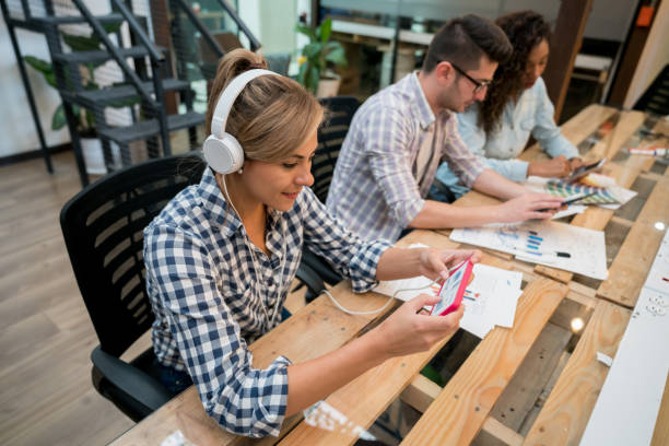 istock Creative woman listening to music while working at the office 912996600