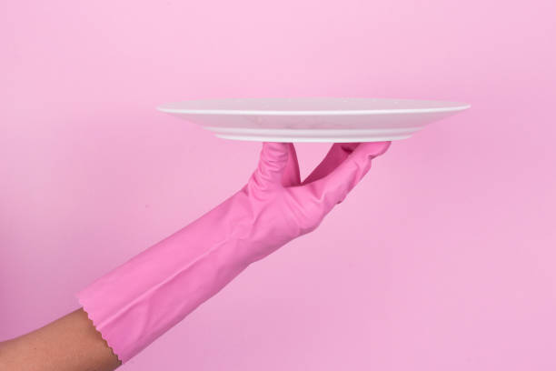 istock Hands in pink protective gloves washing a plate 912997330