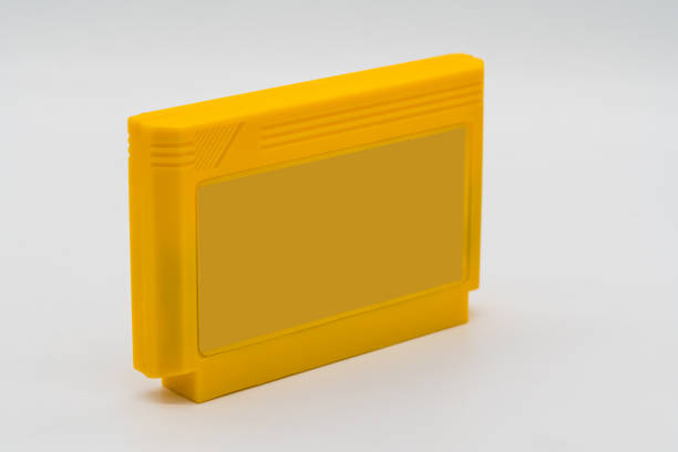 istock TV game cartridge in plastic yellow case from 90s isolated on white background.  Selective focus 913000538