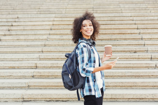 istock Student girl with backpack and mobile at concrete steps background 913001444