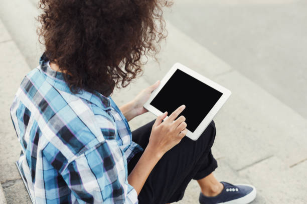 istock Happy young woman using digital tablet outdoors 913001462