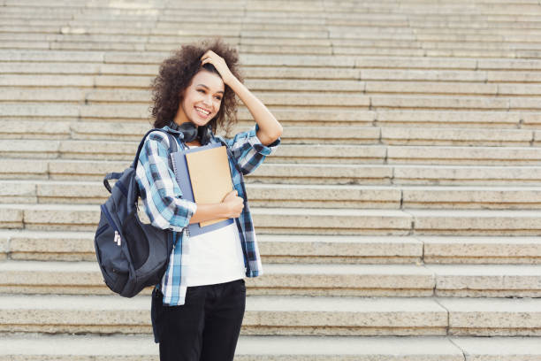 istock Student girl with backpack and workbooks at concrete steps background 913001538