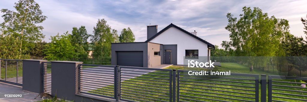 House with fence and garage Exterior view of a house with fence and garage, panorama Fence Stock Photo