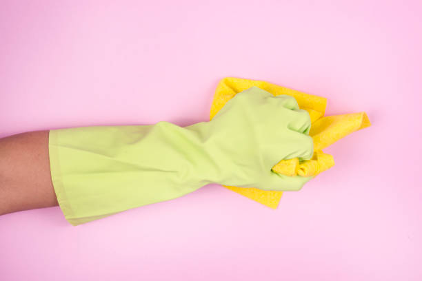 istock Hand in green protective glove cleaning with rag 913010432