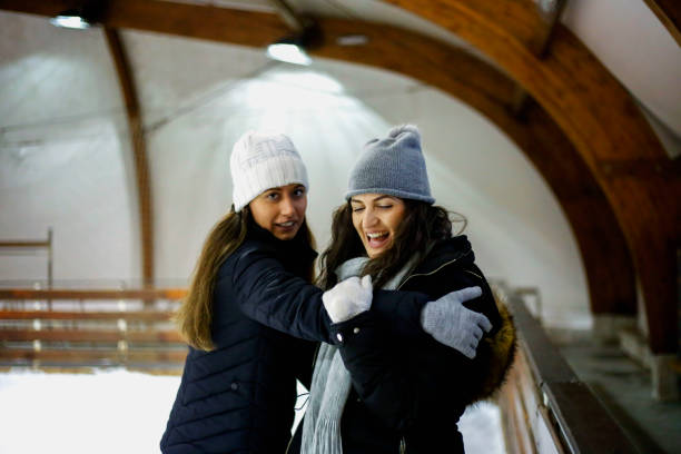 istock Two young positive women on ice rink holding hands to support each other 913010838