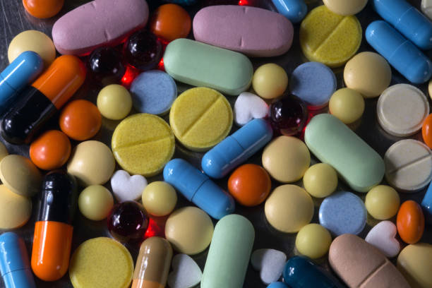 A bunch of multicolored tablets and capsules A bunch of multicolored tablets and capsules big pharma stock pictures, royalty-free photos & images