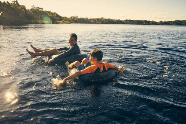 Having fun with my son in the sun Shot of a father and son enjoying a day outdoors inner tube stock pictures, royalty-free photos & images