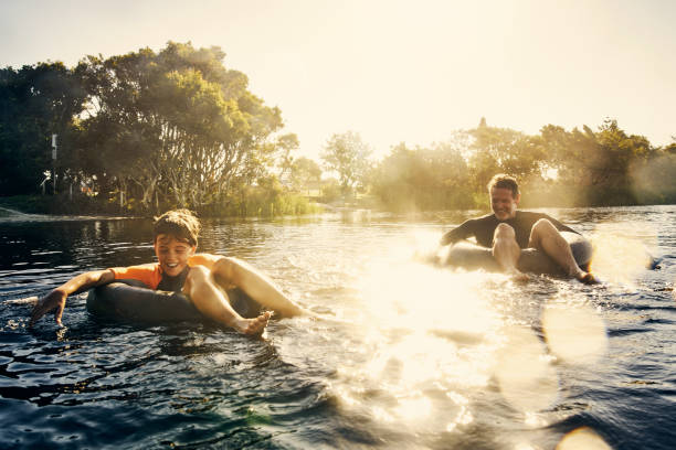 Having such fun today Shot of a father and son enjoying a day outdoors lake water stock pictures, royalty-free photos & images